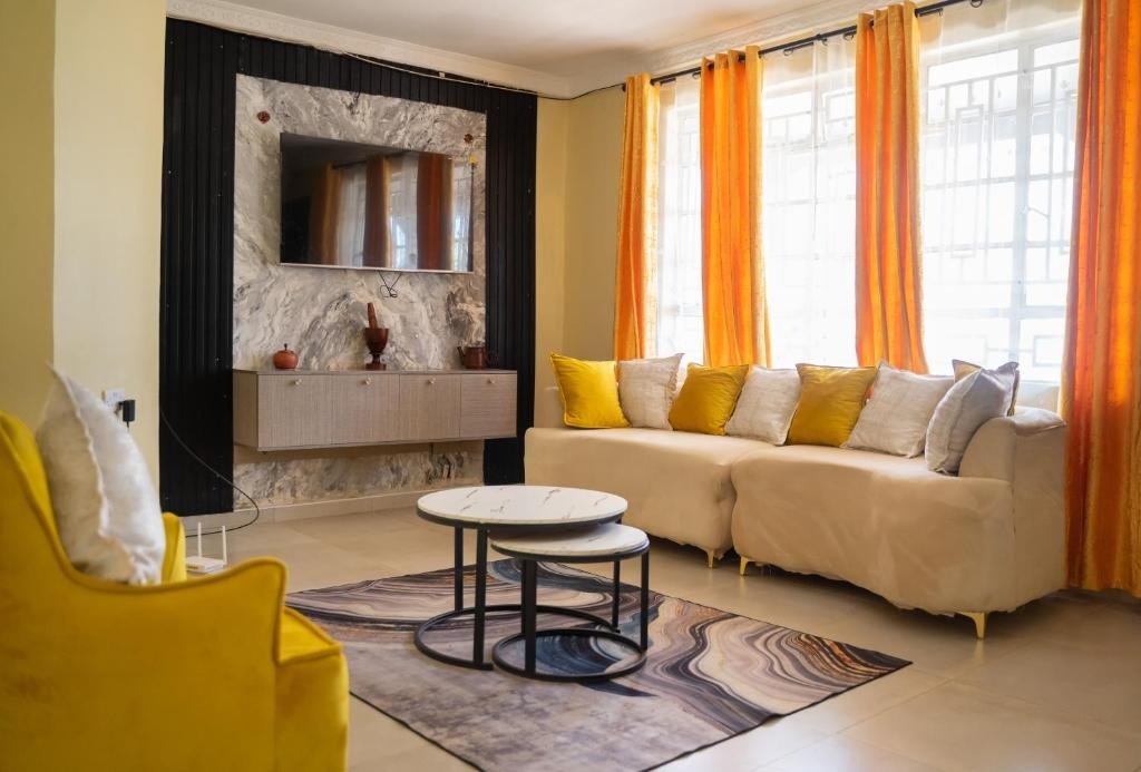 Living room with sofa, armchairs and flat-screen TV