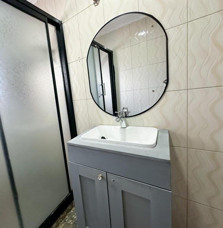 Bathroom with shower enclosure, sink and mirror