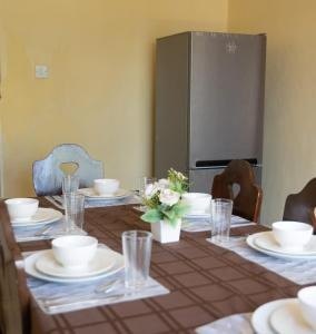 Dining table set for a meal, with refrigerator behind